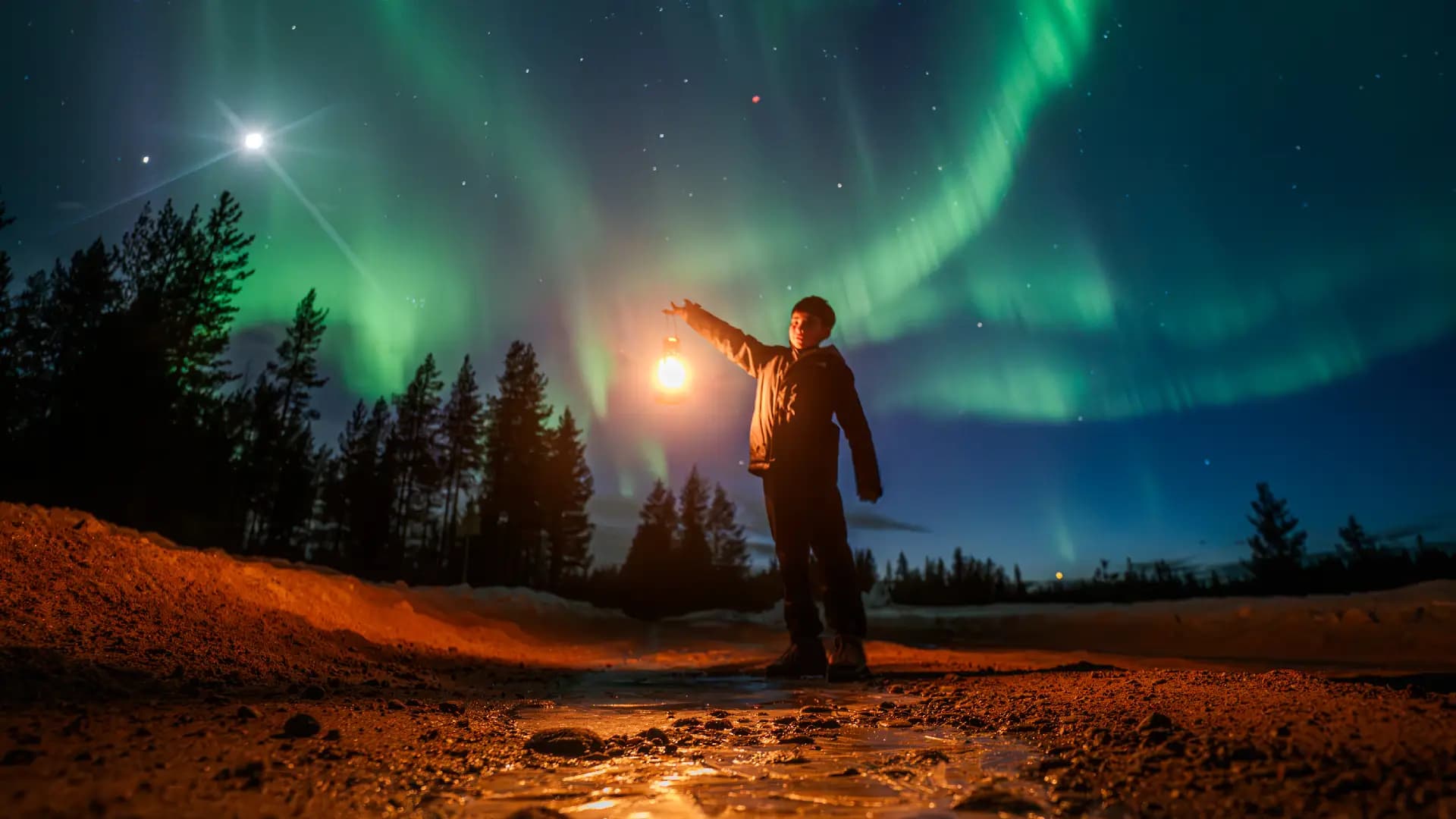 Traveller holding a lantern under bright Northern Lights in Lapland